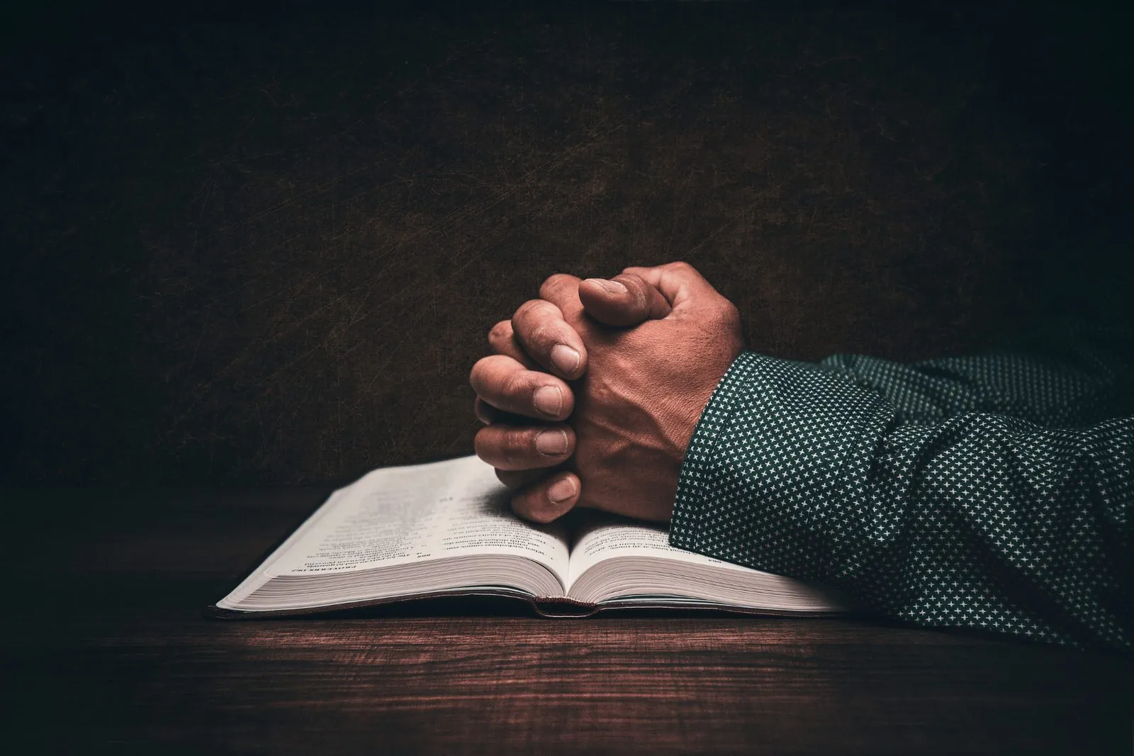Pastor in prayer over Scripture
